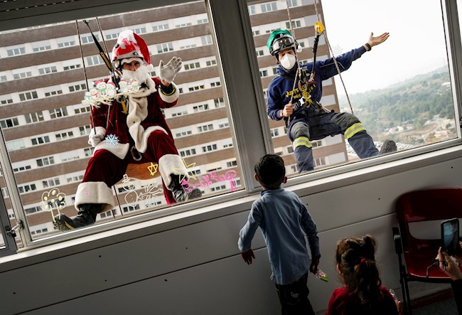 El colectivo Bombers Solidaris, con la colaboración de la Fundación Enriqueta Villavecchia, se han deslizado desde la azotea hasta el séptimo piso del Hospital Trias i Pujol de Badalona para que Papa Noel y dos elfos visitasen a los niños ingresados y a los sanitarios. EFE