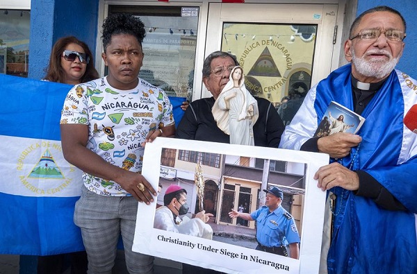 Nicaragüenses rezan guiados por el sacerdote católico José Palmar en la entrada de la sede del Consulado de Nicaragua en Miami, Florida, EE.UU.