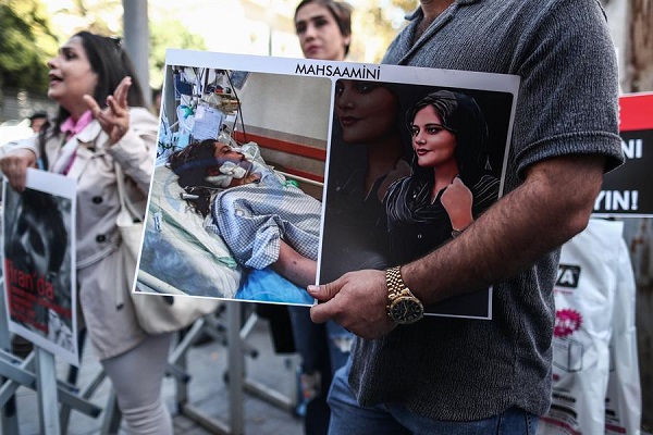 Un iraní sostiene una foto de Mahsa Amini durante la protesta en Irán tras la muerte de la joven.