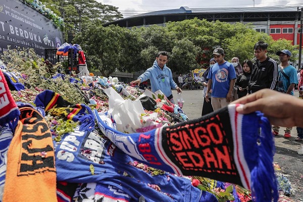 La gente arroja flores para expresar sus condolencias a las víctimas del motín y la estampida del partido de fútbol frente al estadio Kanjuruhan en Malang, Java Oriental, Indonesia.