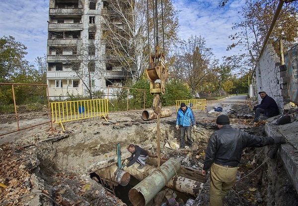 Trabajadores ucranianos reparan las comunicaciones de calefacción dañadas de edificios residenciales dañados en Kharkiv, noreste de Ucrania.