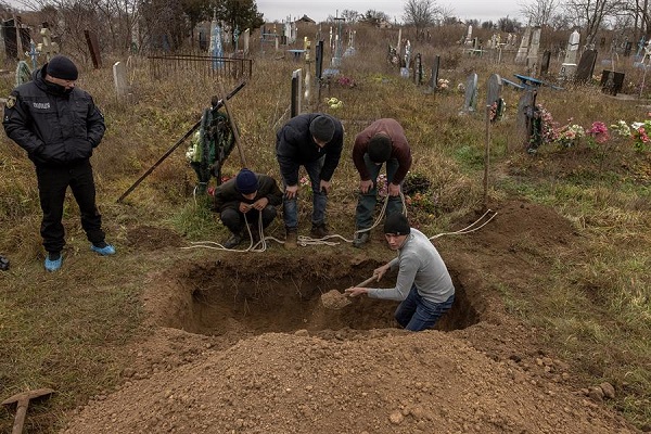 Los residentes locales ayudan a la policía, los expertos forenses y los fiscales a exhumar los restos de una niña de 15 años presuntamente asesinada durante la ocupación rusa.