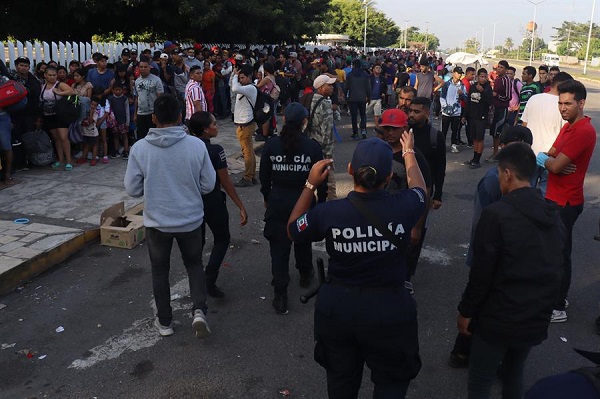 Migrantes hacen fila para tramitar documentos ante el Instituto Nacional de Migración.