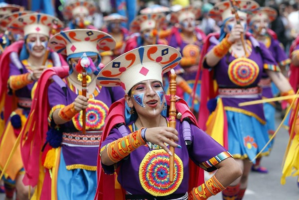 Personas participan en el desfile de los colectivos coreográficos en tributo a la Madre Tierra durante el Carnaval de Negros y Blancos,