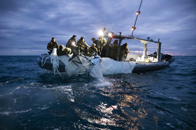 Fotografía cedida por la Armada de Estados Unidos donde aparecen unos marineros asignados al Grupo 2 de Eliminación de Artefactos Explosivos mientras recuperan el globo de vigilancia chino del mar, el 5 de febrero de 2023, frente a la costa de Myrtle Beach, Carolina del Sur (EEUU).