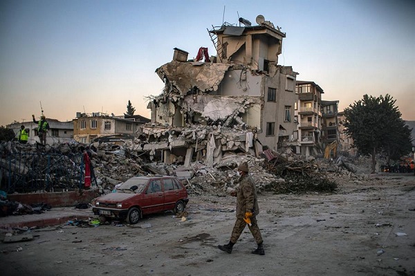 Soldado camina frente a edificios derrumbados después del poderoso terremoto en Hatay, Turquía.