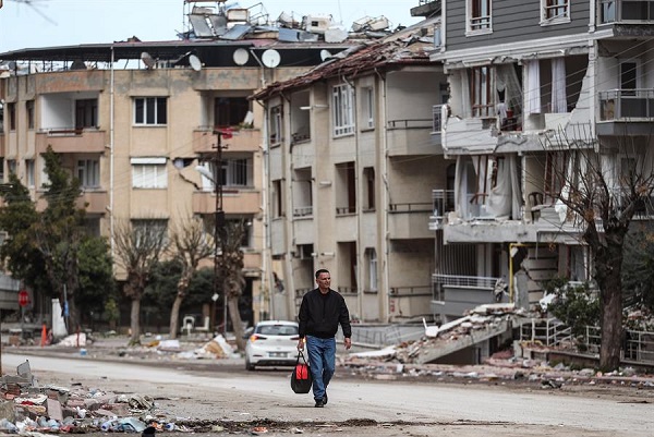 Un hombre camina junto a edificios derrumbados después de un fuerte terremoto en Hatay, Turquía.