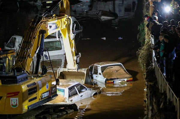 Una excavadora rescata vehículos en aguas de inundación después de que inundaciones mortales azotaran Sanliurfa.