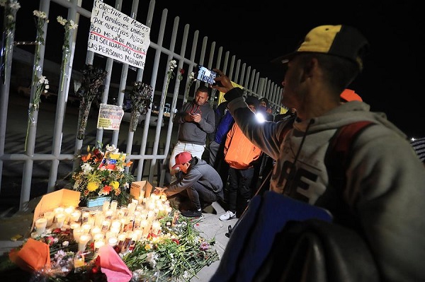 Un grupo de migrantes y familiares de personas fallecidas por un incendio realizan una vigilia en memoria de las 38 víctimas, frente al Instituto Nacional de Migración.