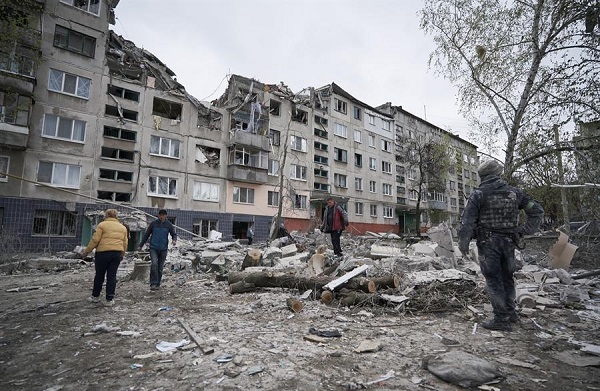 La gente se reúne en la escena de un ataque con cohetes rusos en un edificio residencial en la ciudad de Sloviansk en Donetsk.