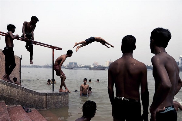 Jóvenes indios se tiran al río Ganjes para refrescarse en una calurosa tarde en Calcuta, la India.