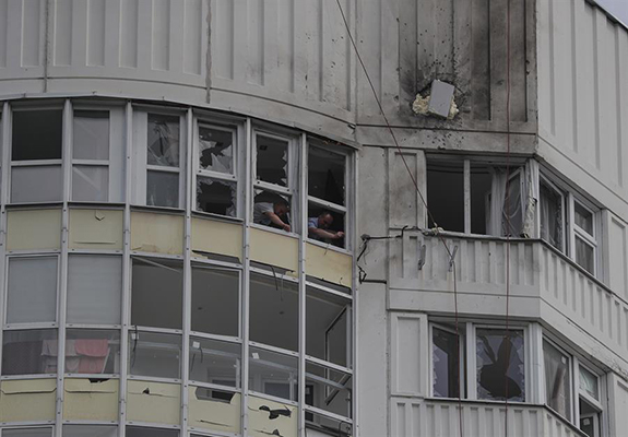 Investigadores rusos trabajan en un apartamento dañado en un edificio residencial luego de un ataque con drones en la capital rusa.