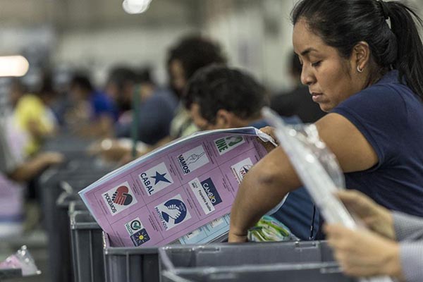 Trabajadores del Tribunal Supremo Electoral empaquetan tarjetones electorales para las elecciones generales del hoy.