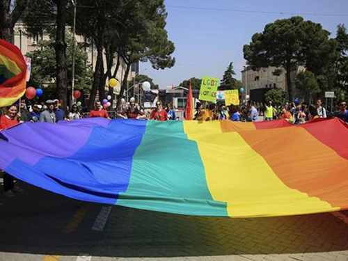 Los símbolos del orgullo gay (la bandera con los colores del arcoiris) se exhiben en abundancia en esta conmemoración.