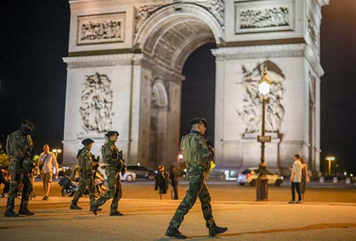 Soldados franceses, que forman parte del plan de seguridad nacional ‘Vigipirate’, vigilan mientras aseguran la zona cercana al Arco del Triunfo, en París.