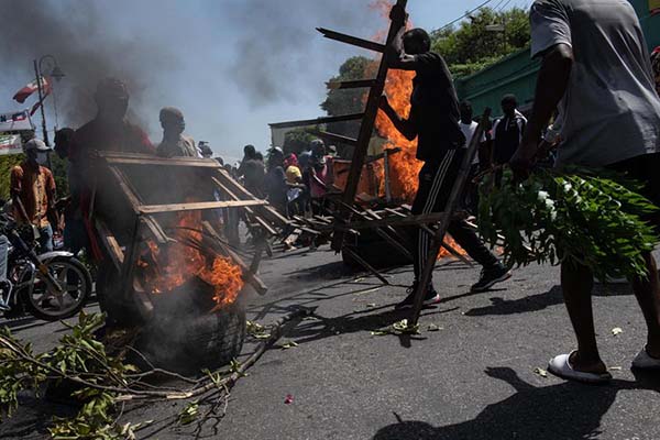 Manifestantes montan una barricada en llamas durante una marcha para exigir seguridad contra las pandillas en Puerto Príncipe.
