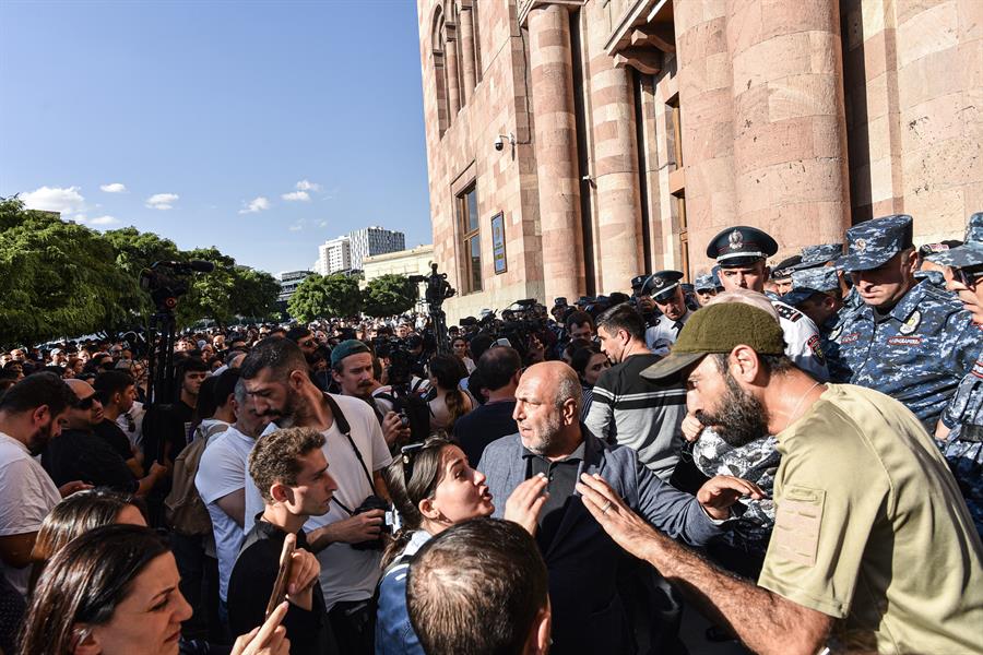 La policía armenia hace guardia mientras la gente se reúne durante una protesta contra las acciones militares de Azerbaiyán.