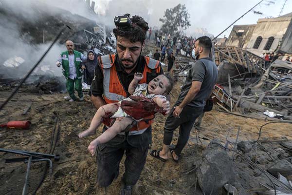 Un palestino carga a un bebé herido que recuperó de los escombros de una zona destruida tras los ataques aéreos israelíes en la ciudad de Gaza.