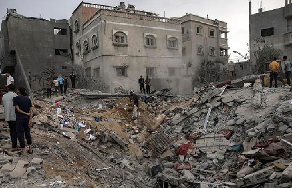 Palestinos buscan cadáveres y supervivientes entre los escombros de un edificio residencial tras un ataque israelí en Khan Younis, sur de la Franja de Gaza.