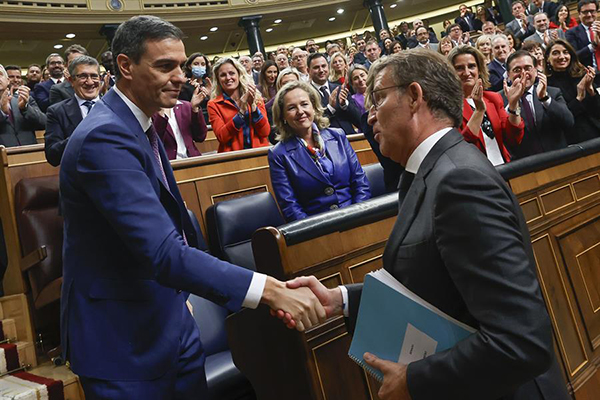 El líder del PP, Alberto Núñez Feijóo felicita al presidente del Gobierno, Pedro Sánchez, al término de la segunda jornada del debate de investidura.
