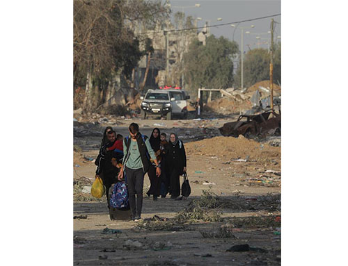 Palestinos caminan después de cruzar desde el norte de la Franja de Gaza al sur de la Franja de Gaza a lo largo de la carretera Salah Al Din en el centro de la Franja de Gaza.