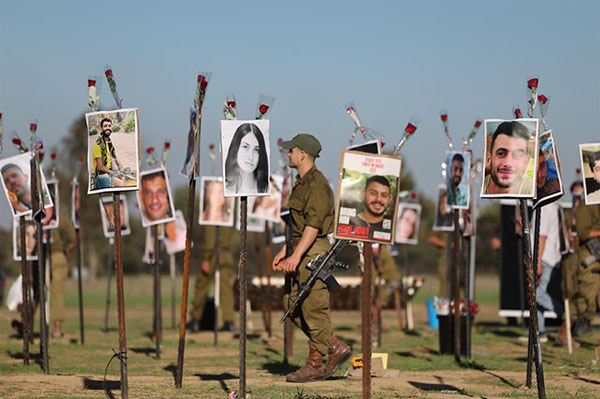 Soldados israelíes miran fotografías de las víctimas del festival de música Nova en el lugar del festival cerca del Kibbutz Reim, cerca de la frontera con Gaza en el sur de Israel.