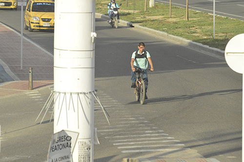 Teniendo al lado la ciclovía, un hombre prefiere arriesgar su integridad transitando por la carretera Troncal del Caribe. 