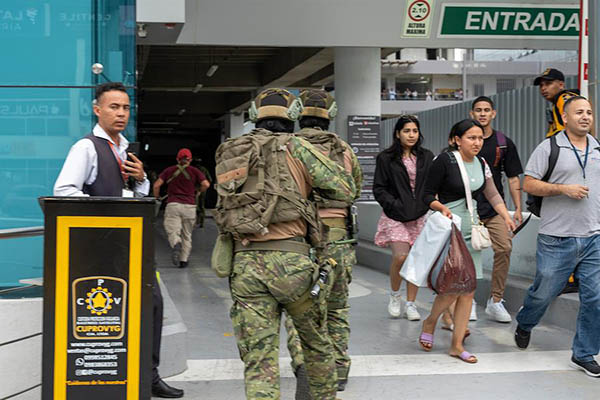 Soldados ecuatorianos persiguen a presuntos delincuentes mientras ciudadanos evacúan los locales comerciales. Soldados ecuatorianos persiguen a presuntos delincuentes mientras ciudadanos evacúan los locales comerciales.