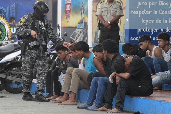 Un policía custodia a los detenidos de un grupo armado por la toma temporal de un canal de televisión ayer, en Guayaquil. Un policía custodia a los detenidos de un grupo armado por la toma temporal de un canal de televisión ayer, en Guayaquil.