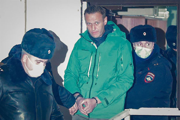 El líder de la oposición rusa y activista anticorrupción Alexey Navalny es escoltado fuera de una comisaría de policía en Khimki, en las afueras de Moscú, el 18 de enero de 2021.