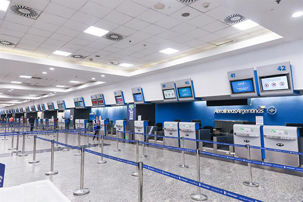 Fotografía de puntos de registro sin filas de pasajeros ni personal de atención en el Aeroparque Jorge Newbery en Buenos Aires.