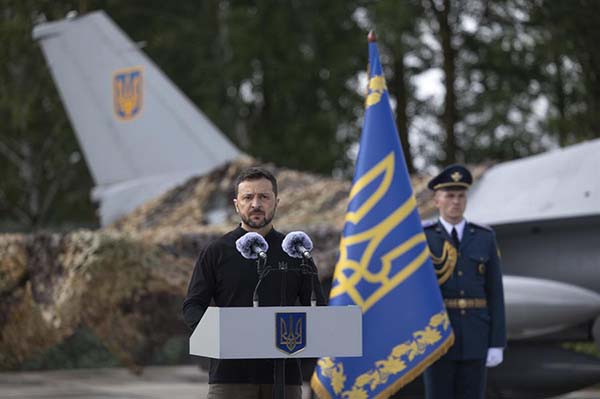 El presidente ucraniano, Volodymyr Zelensky, hablando con militares junto a un avión de combate supersónico. EFE 