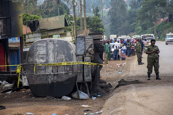 Un miembro de las fuerzas de seguridad ugandesas se encuentra junto a los restos de un camión cisterna de combustible que explotó en Kigoogwa, al norte de Kampala.