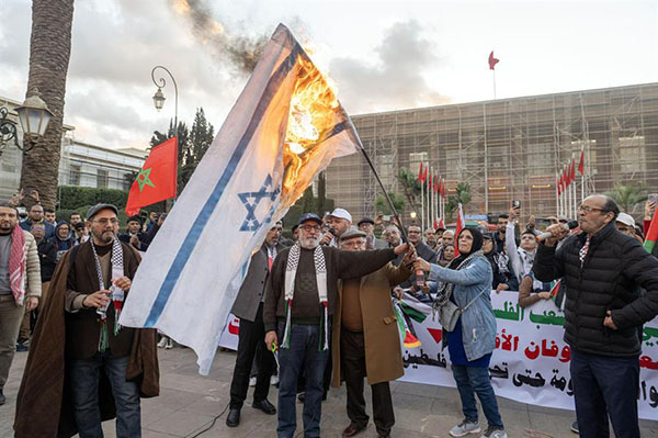 Los marroquíes queman una bandera israelí durante la celebración del acuerdo de alto el fuego entre Hamás e Israel, en Rabat, Marruecos. Los marroquíes queman una bandera israelí durante la celebración del acuerdo de alto el fuego entre Hamás e Israel, en Rabat, Marruecos.