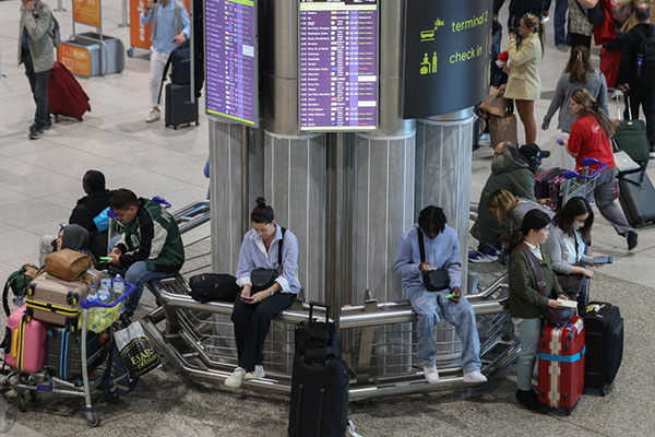Pasajeros esperan en el aeropuerto Humberto Delgado tras la reanudación de la mayoría de los controles de embarque tras un apagón importante, en Lisboa. EFE