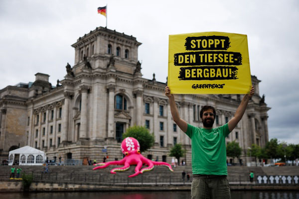 Un activista de Greenpeace sostiene una pancarta con el lema “¡Alto a la minería de aguas profundas!” frente a un pulpo inflable frente al Parlamento alemán en Berlín, Alemania, este lunes. La organización ambiental Greenpeace realizó la protesta con un pulpo inflable de diez metros de altura con motivo del inicio de la reunión de la Autoridad Internacional de los Fondos Marinos (ISA), que se celebra en Jamaica (Foto EFE/EPA/Clemens Bilan) 