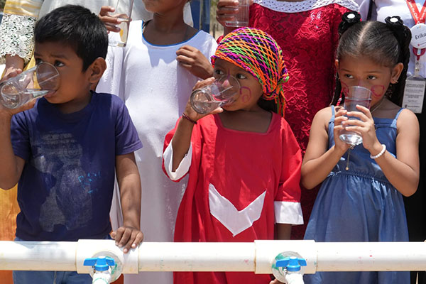Niños indígenas de La Guajira tomando agua potable por primera vez. Foto Minvivienda.
