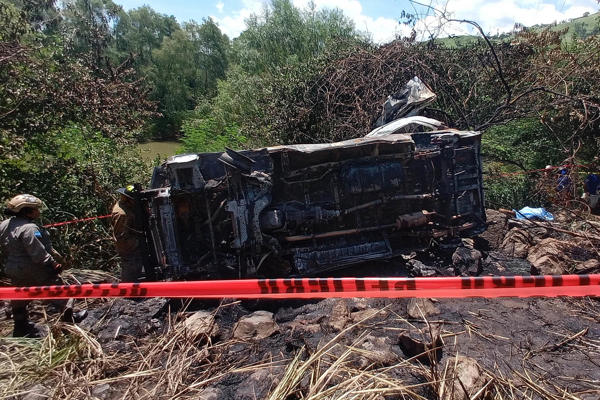 Integrantes del cuerpo de bomberos inspeccionan la zona donde un bus de transporte público, que cubría la ruta entre Cofradía y San Pedro Sula, se accidento este domingo, en la colonia Lempira en San Pedro Sula (Honduras). Al menos dos personas murieron y otras seis resultaron heridas en un accidente de un microbús que tras caer en una hondonada se incendió, según informes preliminares del Cuerpo de Bomberos. EFE/ José Valle 