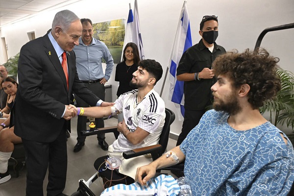El primer ministro israelí, Benjamín Netanyahu, saluda a unos soldados heridos a su llegada al centro médico que acogerá y tratará a los rehenes israelíes que serán liberados por Hamás. EFE/GOP