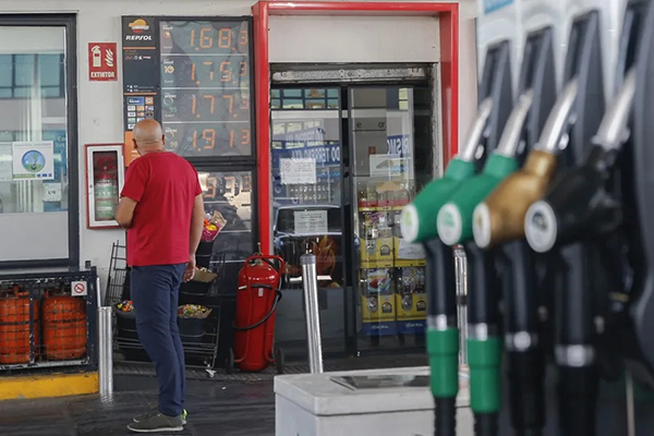 Un hombre pagando por el servicio de tanqueo de gasolina en una estación de servicio. Foto EFE 