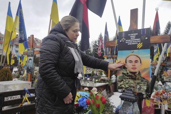 Natalia Kozak, de 45 años, visitó la tumba de su hijo, Bogdan, quien cayó en combate después de unirse voluntariamente al ejército a la edad de 17 años, este martes en el cementerio de Leópolis, Ucrania. EFE/ Rostyslav Averchuk