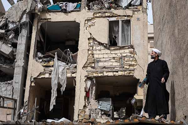 Un clérigo trabaja en un edificio atacado en la calle Rajaei del sureño barrio de 13 de Aban que fu bombardeado en la madrugada por Estados Unidos e Israel donde trabajaban desescombrando. EFE/Jaime León
