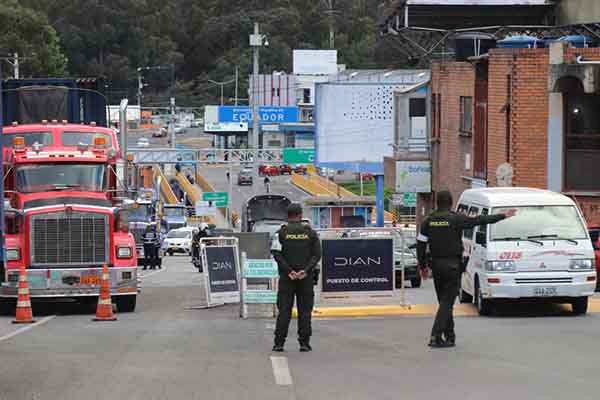 Integrantes de la Policía inspeccionan vehículos durante su paso por el puente internacional de Rumichaca, fronterizo entre Colombia y Ecuador. EFE/ Xavier Montalvo