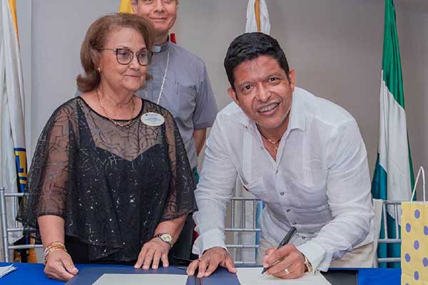 El rector Pablo Vera junto a  Cecilia Navarro, Goberndora del Club de Leones y Monseñor José Mario Bacci como testigo, firmando el convenio. Foto Unimagdalena