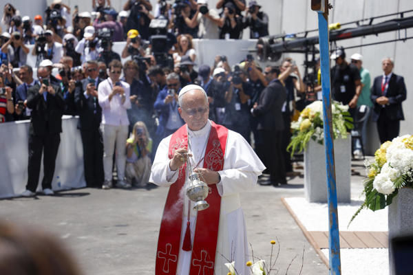 El papa León XIV bendice una cruz (d) hecha con madera procedente de cayucos durante el encuentro con más de un millar de inmigrantes  en la isla de Gran Canaria, este jueves, en el sexto día de su viaje a España. EFE/Laura Bautista
