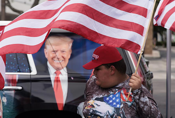 Los partidarios del expresidente Donald Trump se reúnen cerca de la entrada del campo de golf Trump National Doral Miami para una manifestación para mostrar su apoyo.