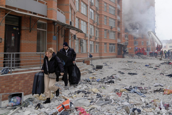 Lugareños caminan entre los escombros después de salir de su apartamento en el sitio de un edificio residencial dañado después de un bombardeo en Odesa.