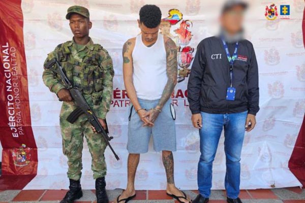 Alias ‘El Tuerto’ o ‘Gordo Flaco’, esposado al lado de un uniformado del Ejército Nacional y un funcionario de la Fiscalía.