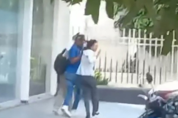 Este el momento en el que los asaltantes salen de la entidad de créditos con una mujer que tomaron como rehén.