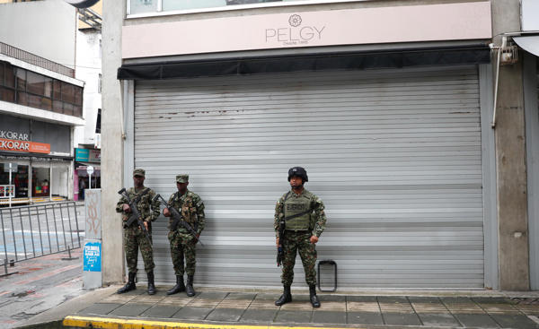 Integrantes de Fuerzas Armadas vigilan un área frente a locales comerciales cerrados este miércoles, en el centro de Cali (Colombia). Cali, la tercera ciudad de Colombia, amaneció con el comercio cerrado y ley seca ordenados por la Alcaldía, que además reforzó la presencia policial en las calles tras los ataques terroristas de la víspera cuando la explosiones de tres motocicletas bomba dejaron dos personas muertas y 42 heridas. EFE/Ernesto Guzmán